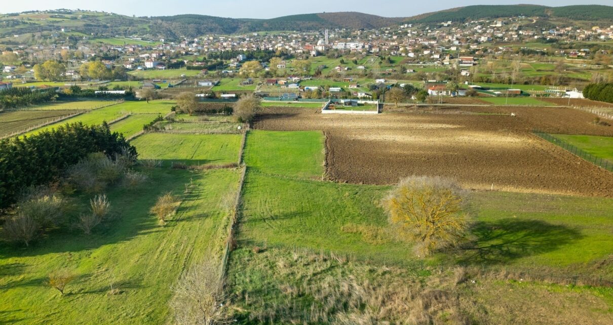 Paysage rural vallonné avec champs cultivés et village dispersé