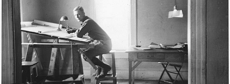 Homme travaillant sur une planche à dessin dans un atelier vintage